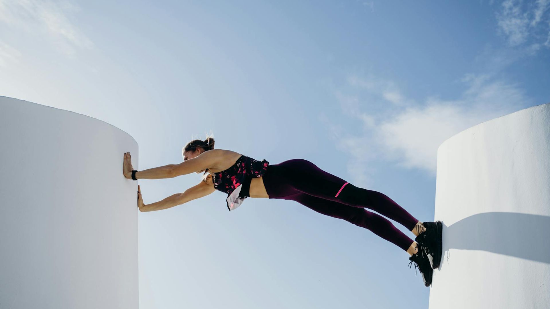 Man performing a controlled bodyweight exercise in a minimalist gym.
